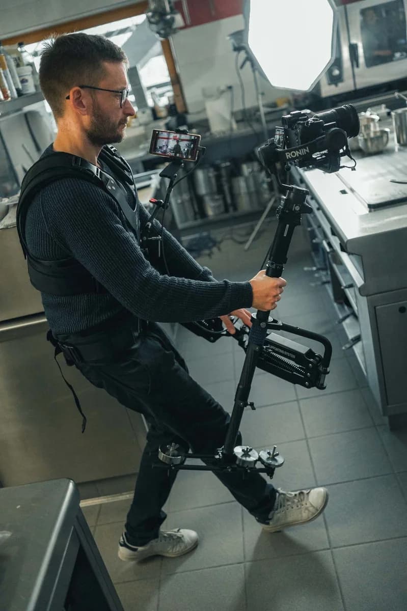 Patrick Steger wearing a gimbal steadicam rig in a kitchen